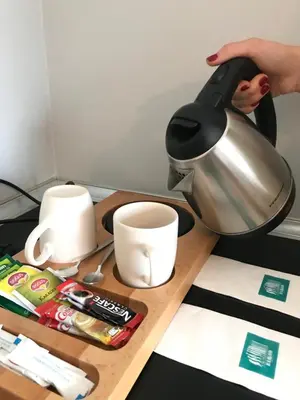 a person pouring coffee into a coffee pot on a table at Barkod Otel in Istanbul