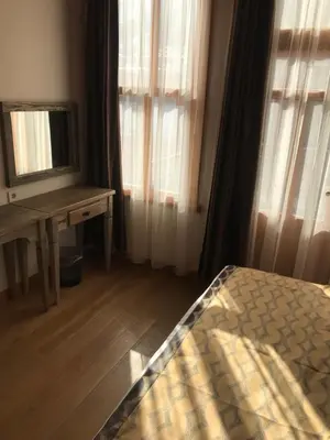 a bedroom with a bed and a desk and a mirror at Green Mansion in Istanbul