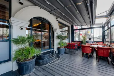 a restaurant with red chairs and tables and windows at Frt Airlines Hotel - Istanbul Airport in Arnavutköy