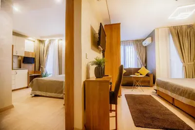 a hotel room with a bed and a living room at Kavalalı Suites in Istanbul