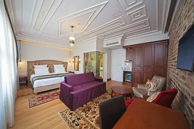 a hotel room with a bed and a purple couch at Azade Premier Hotel in Istanbul