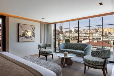 a hotel room with a bed and chairs and a large window at JW Marriott Istanbul Bosphorus in Istanbul