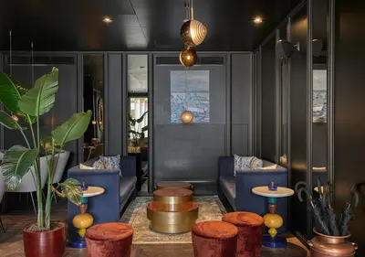 a lobby with blue chairs and tables and plants at Kocatas Mansions in Istanbul