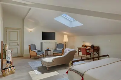 a room with a bed and chairs and a television at Kocatas Mansions in Istanbul