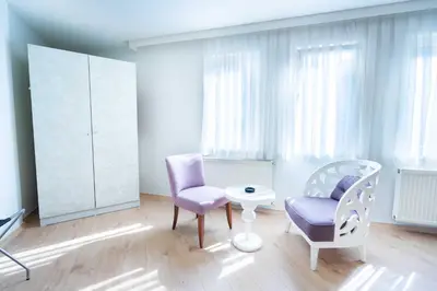 a room with two chairs and a table and a cabinet at Hotel Libiza in Gebze