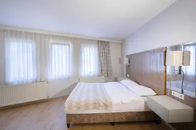a bedroom with a large bed and windows at Hotel Libiza in Gebze