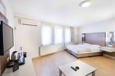 a bedroom with a bed and a tv and a table at Hotel Libiza in Gebze