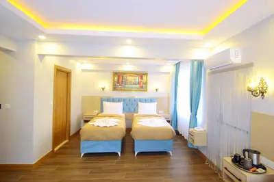 a bedroom with two beds with blue chairs in it at Hira Hotel in Istanbul