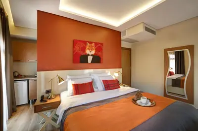 a bedroom with a large bed with an orange wall at The Fox Hotel in Istanbul