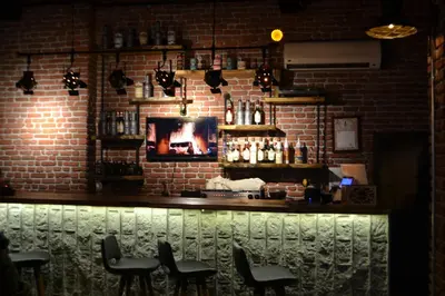 a bar with black chairs and a brick wall at The Wolf Hotel in Istanbul