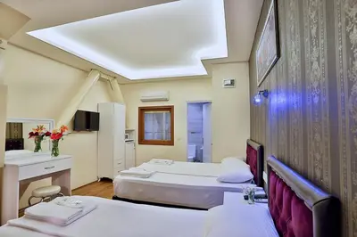 a hotel room with two beds and a desk at Gh Suites Taxim Hotel in Istanbul