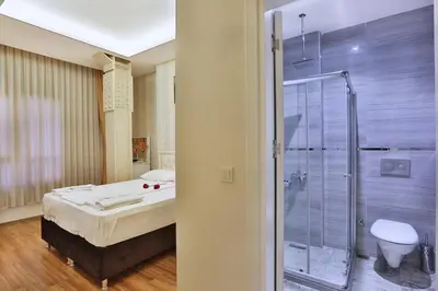 a bathroom with a shower and a bed and a toilet at Gh Suites Taxim Hotel in Istanbul