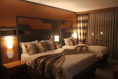 a hotel room with two beds and two lights at Grand Rimedya Hotel Bursa in Panayır
