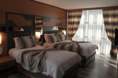 a hotel room with two beds and a window at Grand Rimedya Hotel Bursa in Panayır