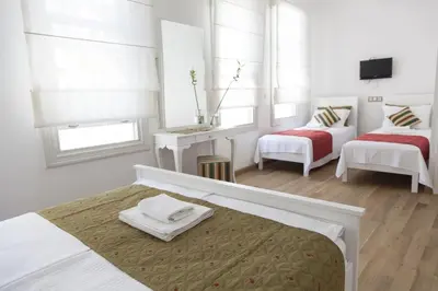 a white bedroom with two beds and a tv at Pi Art Butik Otel in Istanbul