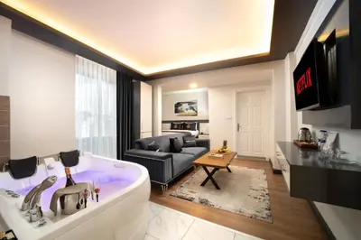 a living room with a large bath tub and a couch at Bakırköy Zeugma Suit Otel in Istanbul