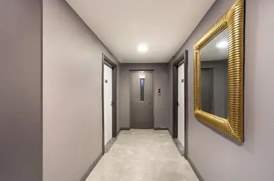 a hallway with a gold framed mirror on the wall at Bakırköy Zeugma Suit Otel in Istanbul