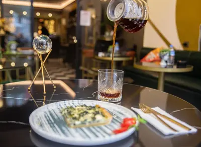 a drink being poured into a plate of food on a table at Lord Morgan & Exclusive Design Residence Nişantaşı in Istanbul
