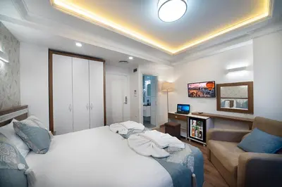 a bedroom with a bed and a couch and a television at Lika Hotel in Istanbul