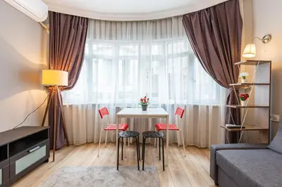 a living room with a table and chairs in front of a window at Oval Flats Old City in Istanbul