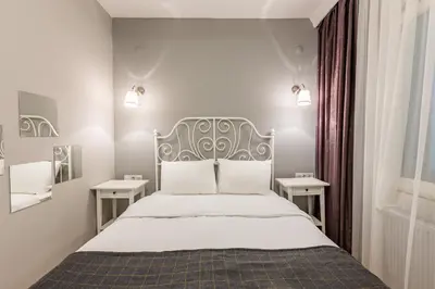 a bedroom with a bed with white sheets and two tables at Oval Flats Old City in Istanbul