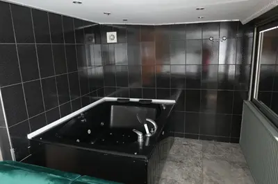 a black tiled bathroom with a bath tub at Comfort Downtown Istanbul Hotel in Istanbul