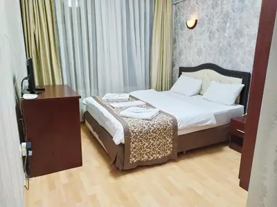 a bedroom with a bed with a desk and a television at Taxim Hotel Marin in Istanbul