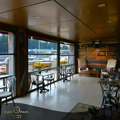 a room with chairs and tables and a yellow car outside at Euro Park Otel in Istanbul