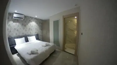 a bedroom with a white bed and a mirror at Le Luxe Suites Hotel in Bursa