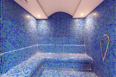 a blue tiled bathroom with a shower with blue tiles at Hotel Boursier 2 & Spa in Istanbul