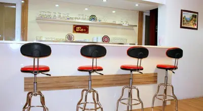 a bar with three stools in front of a counter at Hotel Kuk in Istanbul