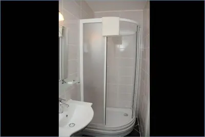a bathroom with a shower and a toilet and a sink at Hotel Kuk in Istanbul