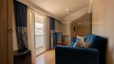 a living room with a blue couch and a window at Farina Hotel By Cigno in Istanbul