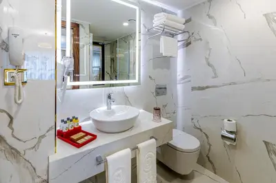 a bathroom with a sink and a toilet and a mirror at Beethoven Senfoni Hotel in Istanbul