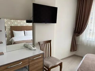 a room with a desk with a phone and a bed at Bursa Malkoc Hotel in Bursa