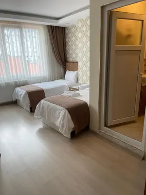 a hotel room with two beds and a mirror at Bursa Malkoc Hotel in Bursa