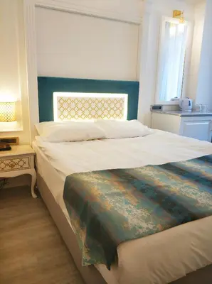 a bedroom with a large bed with a blue headboard at Ligos in Istanbul