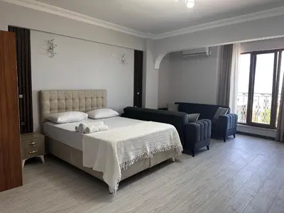 a bedroom with a bed and a couch and a chair at KILIÇ MOTEL in Istanbul