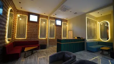 a waiting room with a red couch and mirrors at Grand Sirkeci Hotel in Istanbul