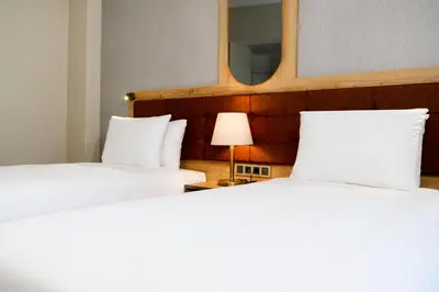 two beds in a hotel room with a mirror at Grand Sirkeci Hotel in Istanbul