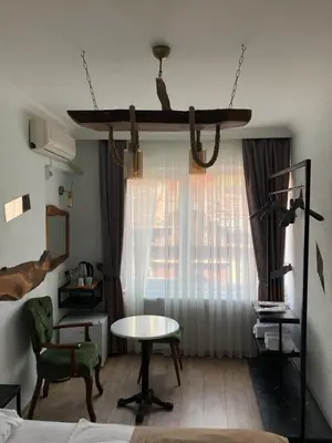 a room with a bed and a table and a window at PANDAN KARAKOY SUİT in Istanbul