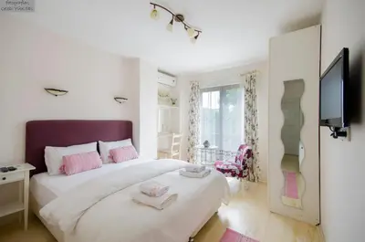 a bedroom with a large white bed with pink pillows at Ağva Piassa Otel in Agva
