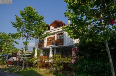 a building on the side of a street with trees at Ağva Piassa Otel in Agva