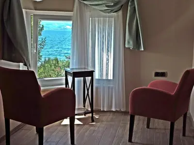 a living room with two chairs and a large window at Senler Boutique Hotel in Sapanca