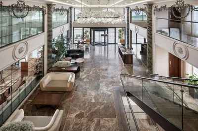 a lobby of a building with escalators and chairs at DoubleTree by Hilton Istanbul Gayrettepe in Istanbul