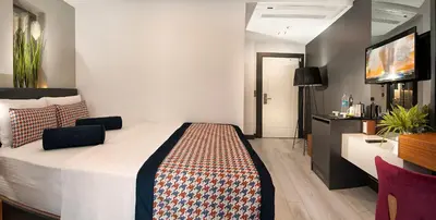 a hotel room with a bed and a flat screen tv at Ooda Rooms Kadıköy in Istanbul