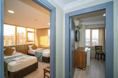 a hotel room with two beds and a balcony at Hotel Simper in Istanbul