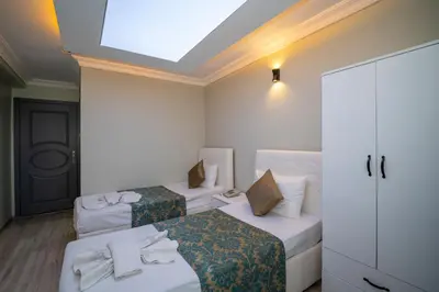 a hotel room with two beds and a skylight at Hotel Simper in Istanbul