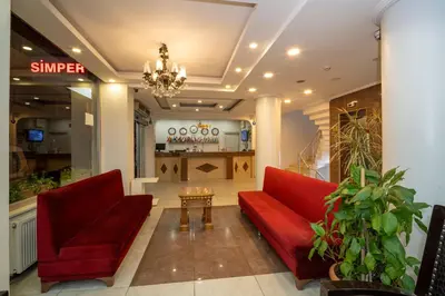 a lobby with two red couches and a table at Hotel Simper in Istanbul