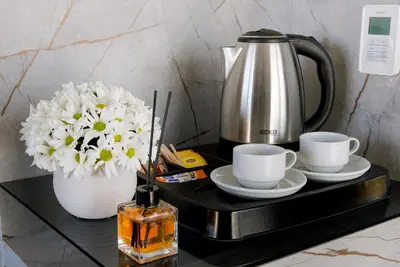 a coffee pot and two cups and flowers on a table at Four Sides Sisli in Istanbul